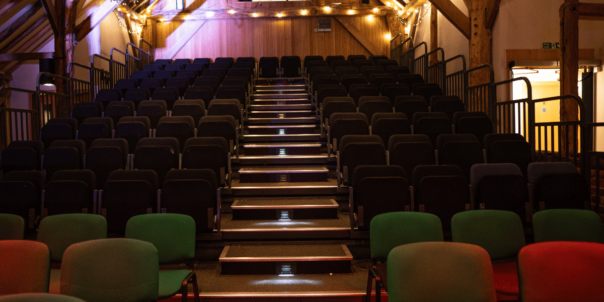 Auditorium of Hanger Farm showing tiered seating with atmospheric lighting. 