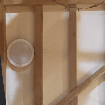New round LED wall light between the wooden beams inside Hanger Farm.