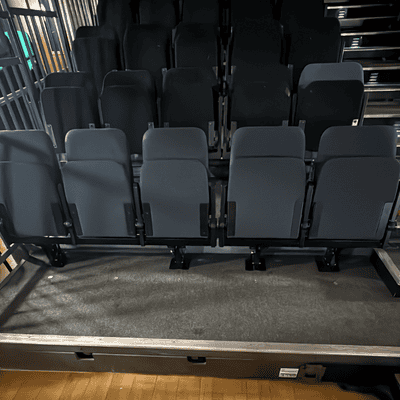 Row of newly installed grey theatre seats in the Hanger Farm auditorium.
