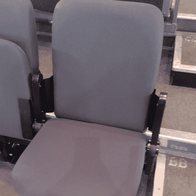 New grey upholstered theatre seat installed in the Hanger Farm auditorium.